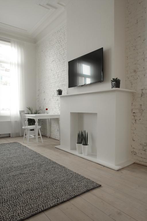 Maison Nationale City Flats & Suites Amberes Habitación foto A fireplace with a TV above it